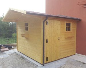 Casetta in legno addossata a parete con finestre