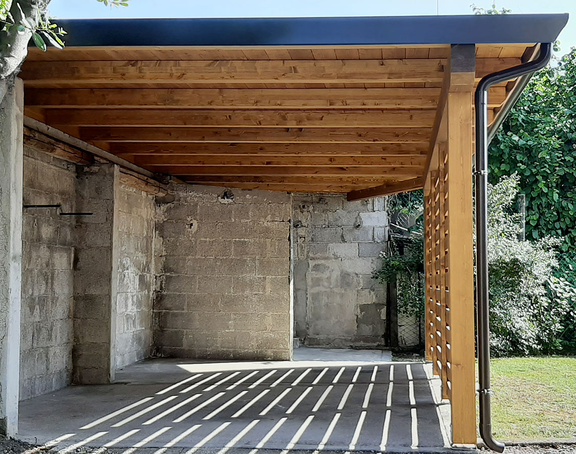 tettoia in legno con pannelli frangivista addossata al muro