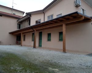 Tettoia in legno addossata alla parete di casa a Pordenone