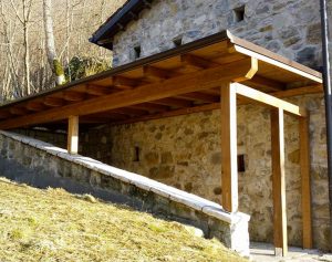Tettoia in legno addossata a parete di un rustico a Conegliano