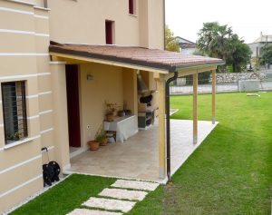 Tettoia in legno addossata a parete con copertura in finto coppo a Pordenone