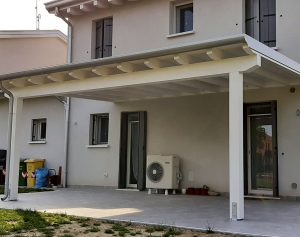 Tettoia in legno con verniciatura bianca addossata a parete
